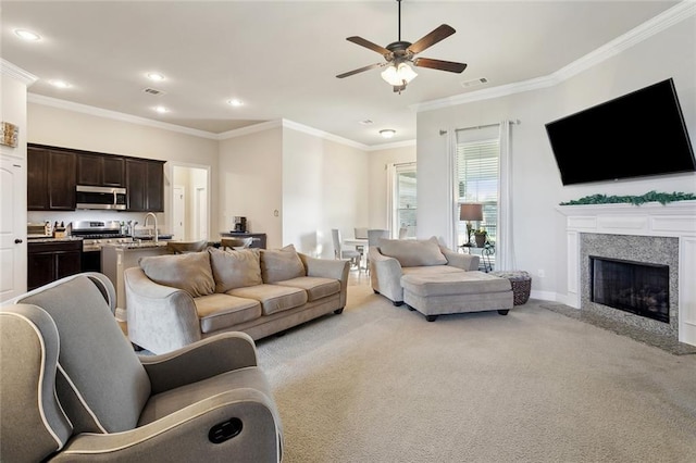 living room featuring crown molding, visible vents, a fireplace with flush hearth, light carpet, and ceiling fan