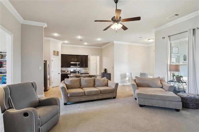 living room with ornamental molding, visible vents, and light colored carpet