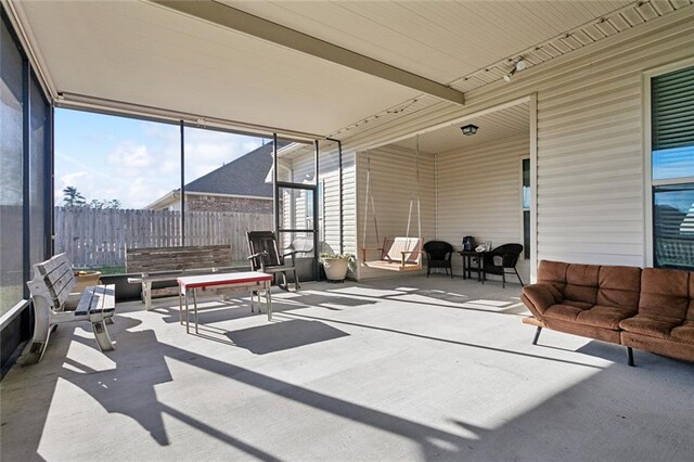 sunroom / solarium featuring rail lighting