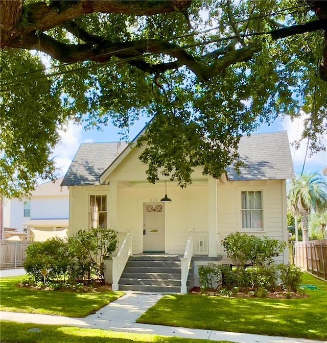 312 W Robert E Lee Blvd, New Orleans, LA 70124 - view of front facade featuring a front lawn, fence, and a shingled roof