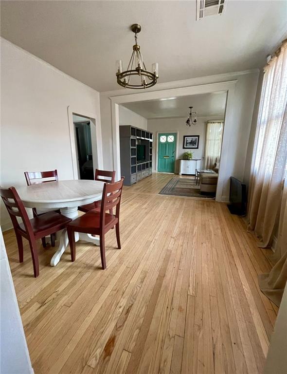 312 W Robert E Lee Blvd, New Orleans, LA 70124 - living area featuring ornamental molding, a notable chandelier, and light wood-type flooring