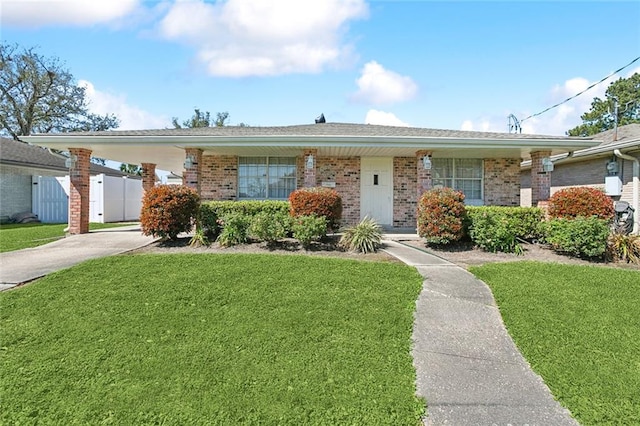 ranch-style home with brick siding, fence, a carport, and a front yard