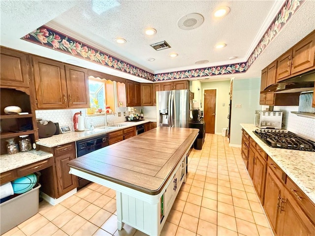 kitchen featuring visible vents, stainless steel fridge with ice dispenser, dishwasher, black gas cooktop, and a sink