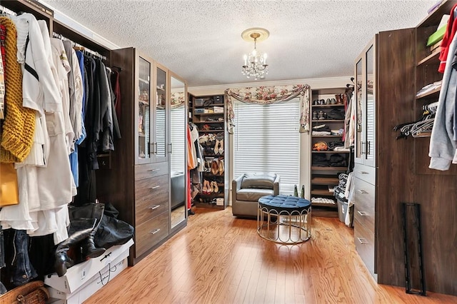 spacious closet featuring a notable chandelier and hardwood / wood-style floors