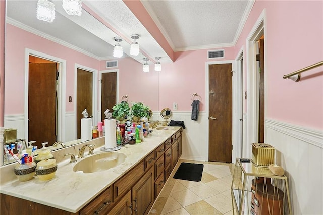 5 Five Oaks Dr, New Orleans, LA 70131 - bathroom with double vanity, wainscoting, a textured ceiling, tile patterned flooring, and crown molding