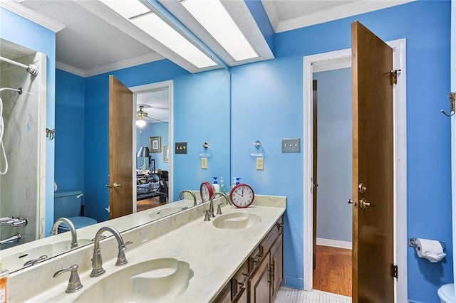 bathroom featuring ornamental molding, toilet, and a sink