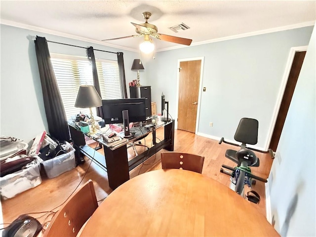 home office featuring crown molding, wood finished floors, visible vents, and baseboards