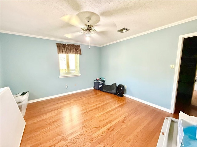 interior space with visible vents, a textured ceiling, baseboards, and wood finished floors