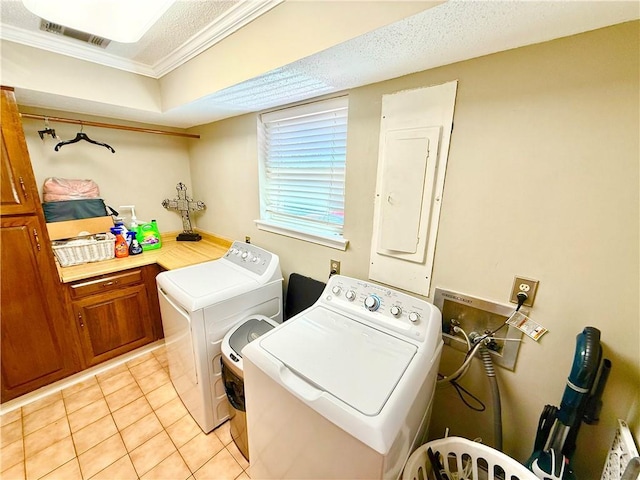 washroom featuring visible vents, electric panel, washing machine and dryer, cabinet space, and light tile patterned flooring