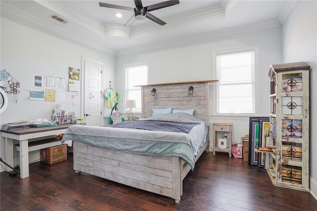 bedroom featuring ornamental molding, wood-type flooring, a raised ceiling, and visible vents