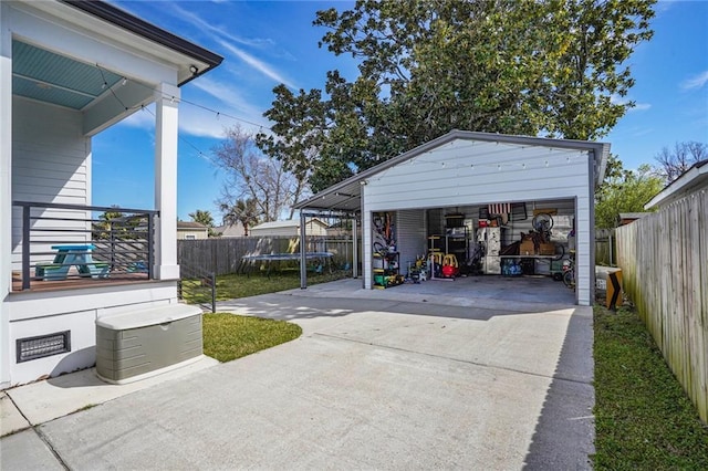 detached garage with a trampoline and fence