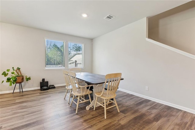 dining room featuring wood finished floors, visible vents, and baseboards