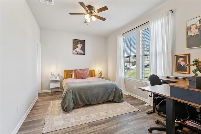 bedroom with visible vents, baseboards, and wood finished floors