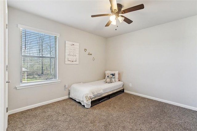 carpeted bedroom featuring ceiling fan and baseboards