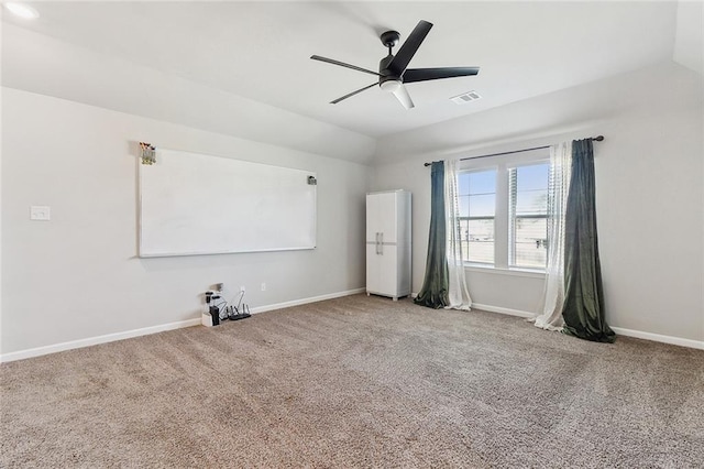 carpeted spare room featuring a ceiling fan, visible vents, vaulted ceiling, and baseboards