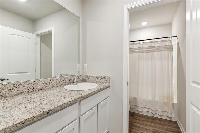 full bathroom featuring wood finished floors and vanity