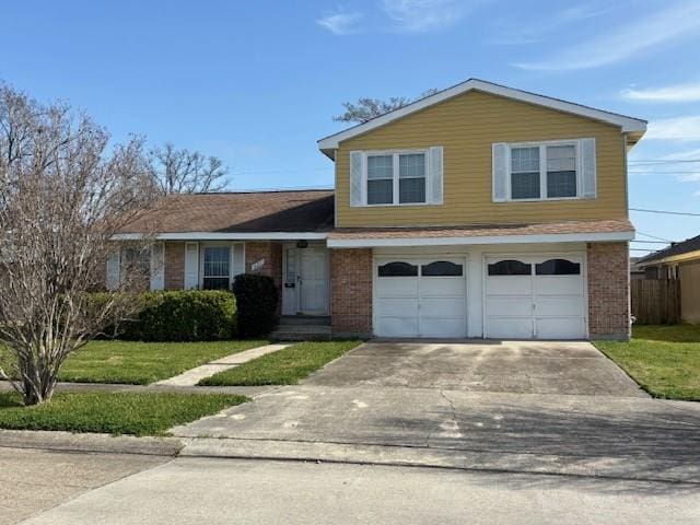 view of front of property with driveway, a garage, fence, a front lawn, and brick siding