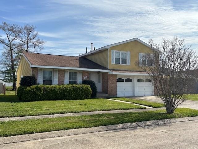 tri-level home with an attached garage, a front lawn, concrete driveway, and brick siding