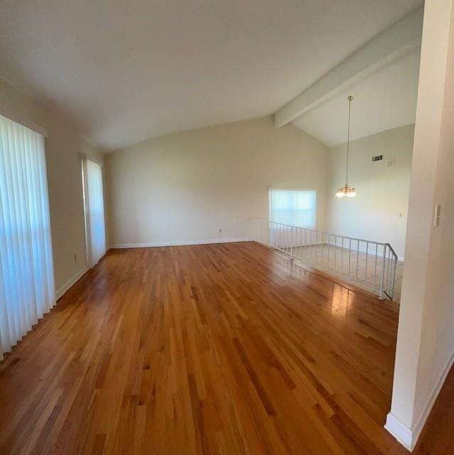 unfurnished room featuring vaulted ceiling with beams, a notable chandelier, baseboards, and wood finished floors