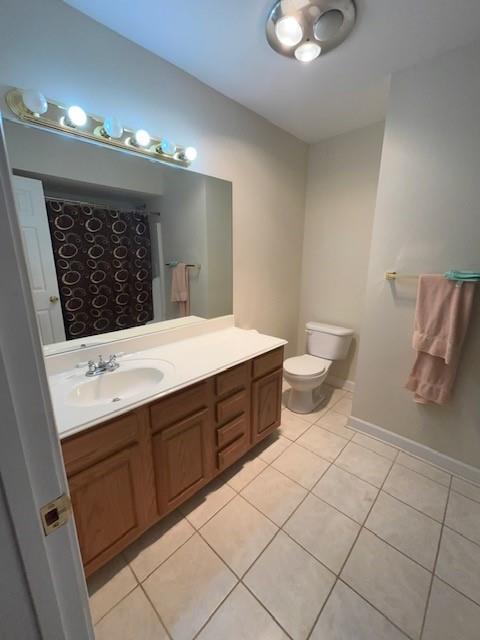 full bath with baseboards, toilet, curtained shower, tile patterned flooring, and vanity