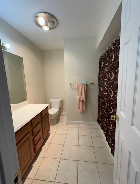 full bathroom with toilet, tile patterned floors, baseboards, and vanity