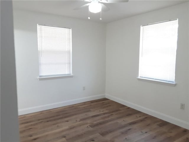 unfurnished room with wood finished floors, a ceiling fan, and baseboards