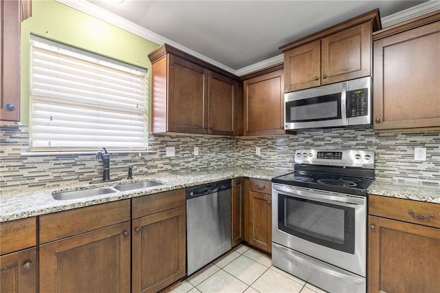 kitchen with light tile patterned floors, decorative backsplash, stainless steel appliances, crown molding, and a sink