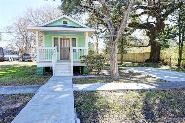 view of front of property featuring fence and a porch