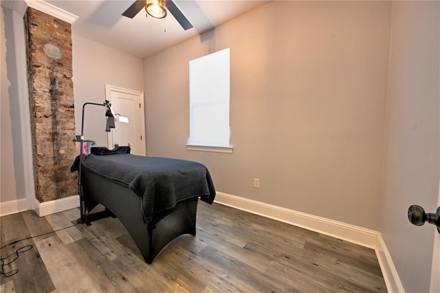 bedroom with ceiling fan, baseboards, and wood finished floors