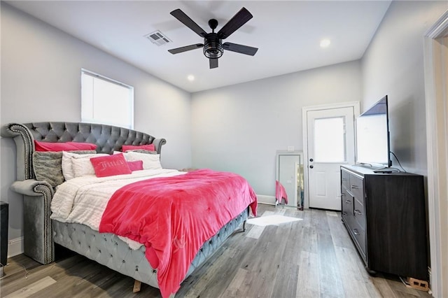 bedroom with baseboards, visible vents, light wood finished floors, and multiple windows