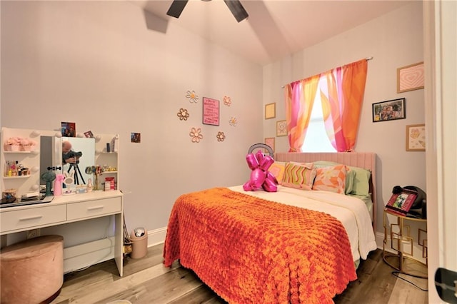 bedroom with a ceiling fan, baseboards, and wood finished floors