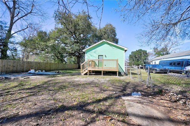 rear view of house featuring fence private yard and a wooden deck