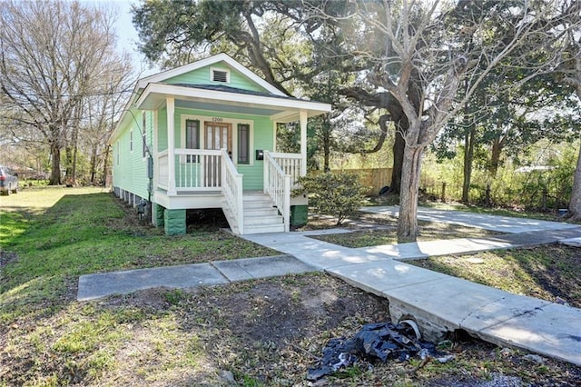 view of front of house featuring covered porch and a front lawn