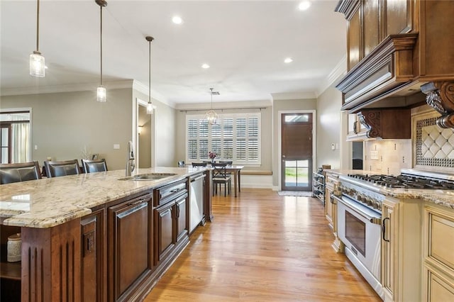 kitchen with tasteful backsplash, light wood-type flooring, a kitchen bar, appliances with stainless steel finishes, and a sink