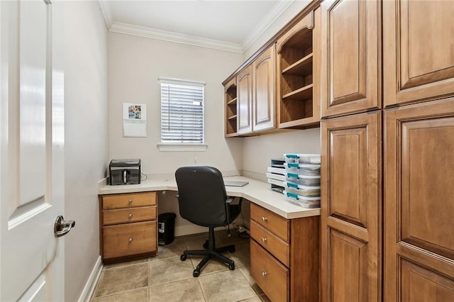 office space featuring crown molding, light tile patterned floors, baseboards, and built in desk