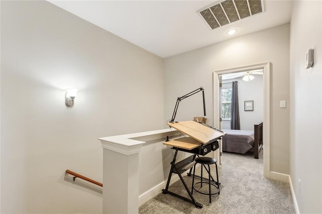 corridor featuring baseboards, visible vents, and light carpet