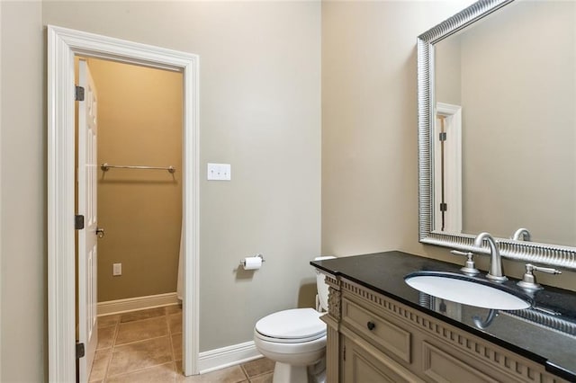 bathroom featuring tile patterned flooring, toilet, vanity, and baseboards