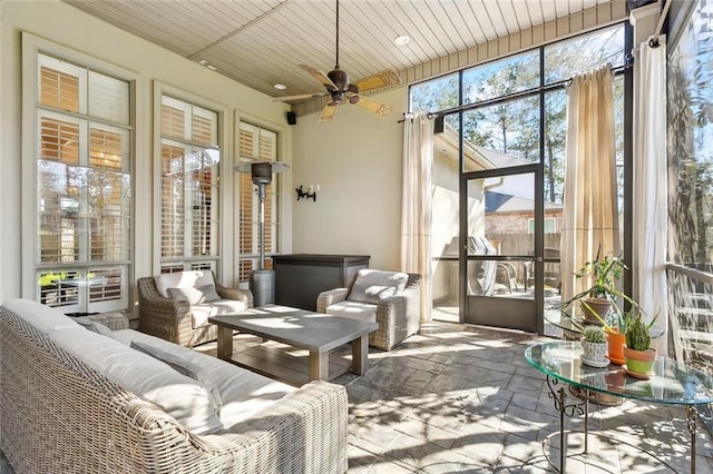 sunroom featuring wooden ceiling and a ceiling fan