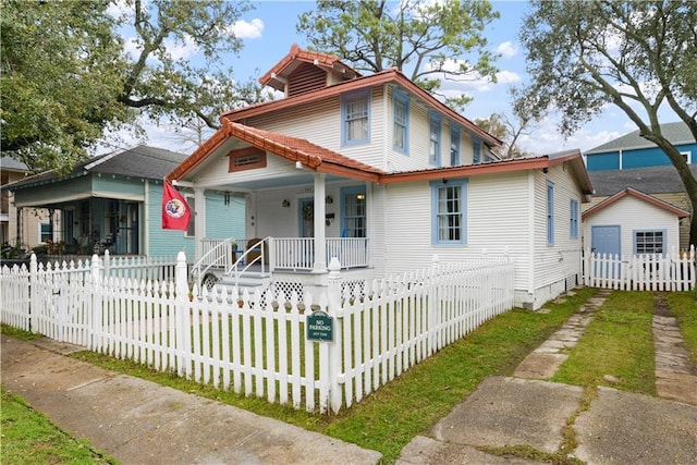 traditional style home with a fenced front yard and a porch