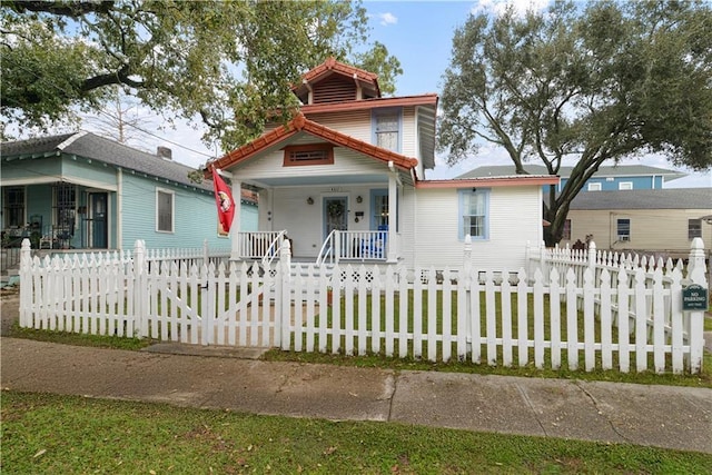 view of front of property featuring covered porch and a fenced front yard