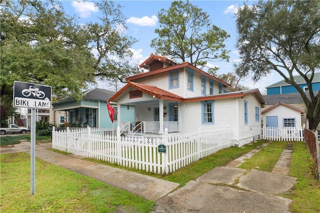 view of front of house with covered porch and a fenced front yard