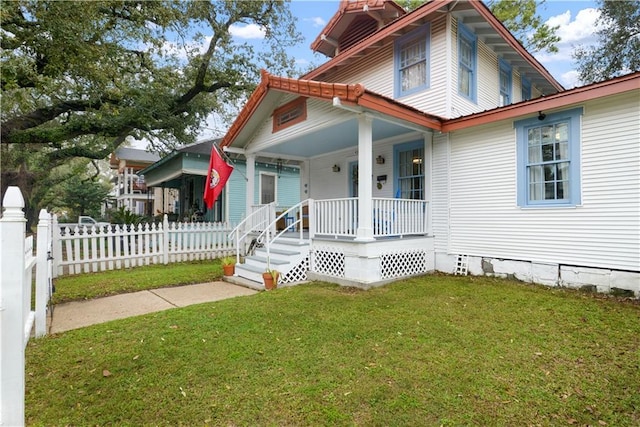 view of front of home with a porch, a front lawn, and fence