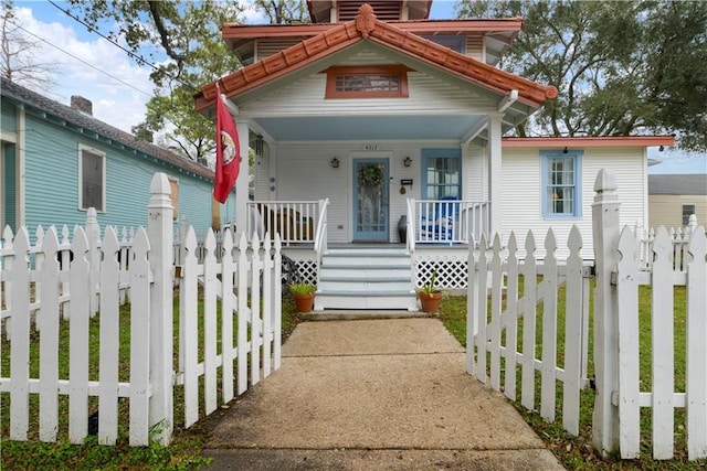 view of front of home featuring covered porch and a fenced front yard