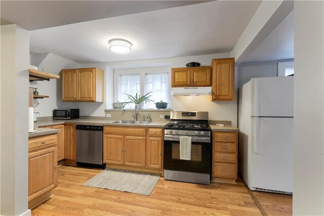 kitchen featuring under cabinet range hood, stainless steel appliances, a sink, light countertops, and light wood-type flooring