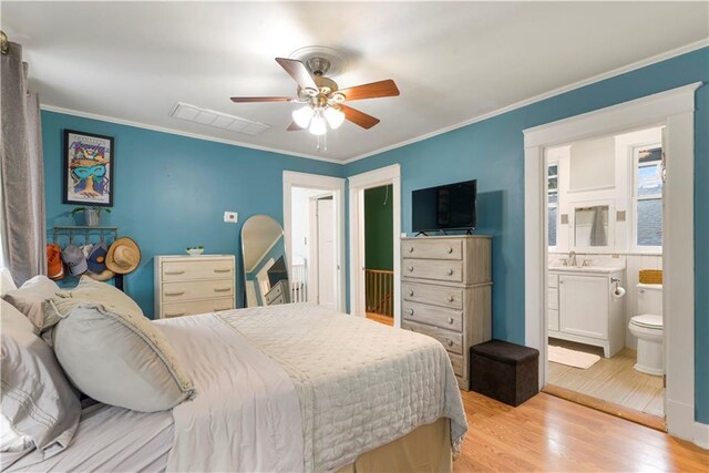 bedroom featuring light wood-style floors, visible vents, and crown molding