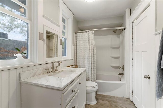 bathroom featuring toilet, shower / tub combo, wood finished floors, and vanity