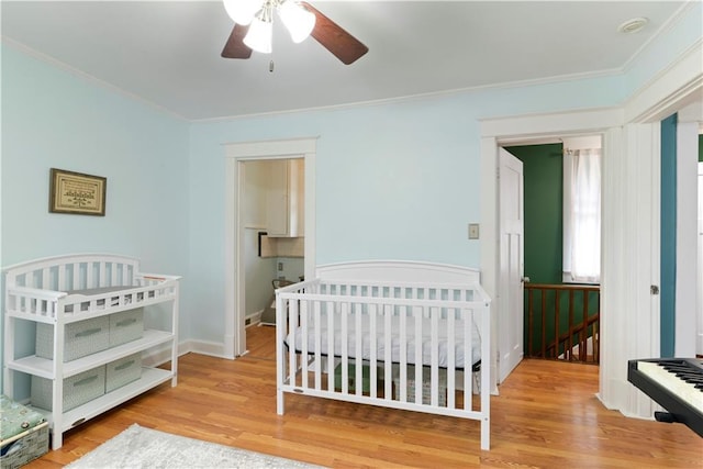 bedroom with baseboards, crown molding, and wood finished floors