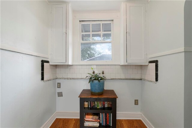 interior details featuring tasteful backsplash, baseboards, and wood finished floors