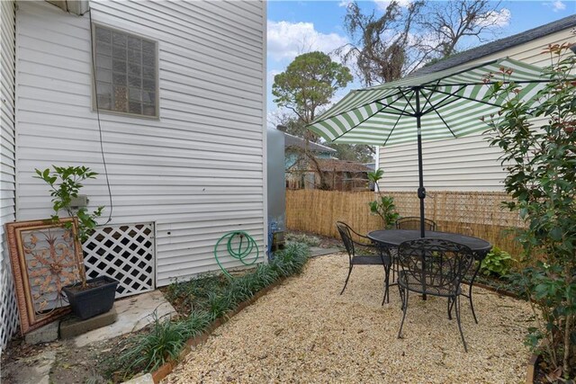 view of patio featuring outdoor dining area and fence