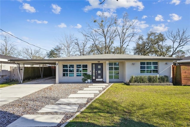 view of front facade featuring concrete driveway, fence, a front lawn, a carport, and stucco siding